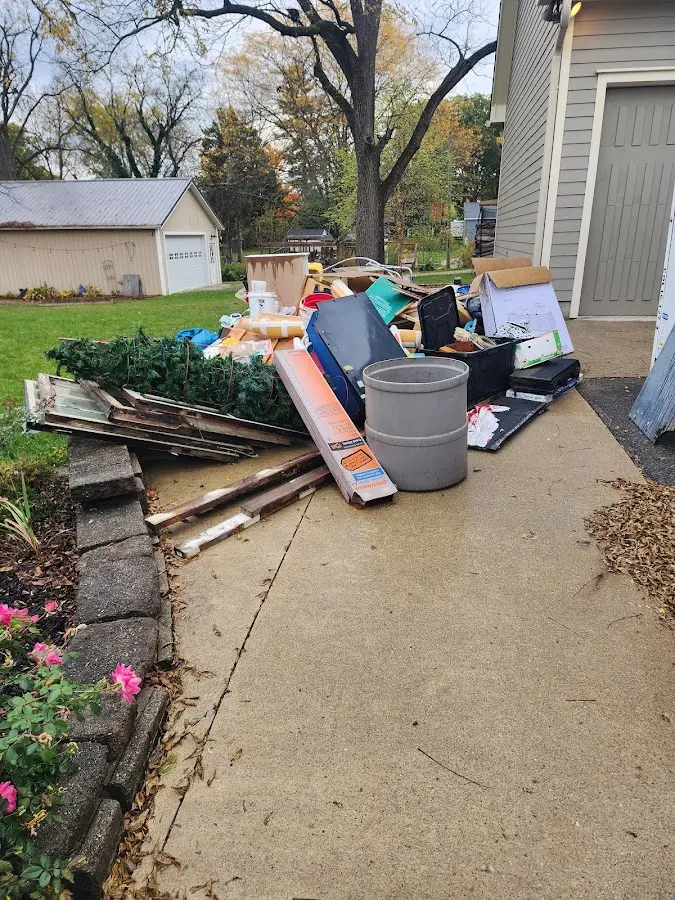 Dumpster being loaded with debris for 12 Yard Dumpster Rental in Freehold